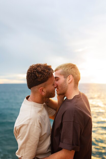 Liebevolles schwules Paar, das Zeit zusammen am Strand verbringt