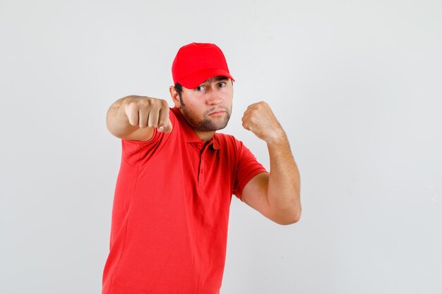 Lieferbote, der in der Boxerhaltung im roten T-Shirt steht