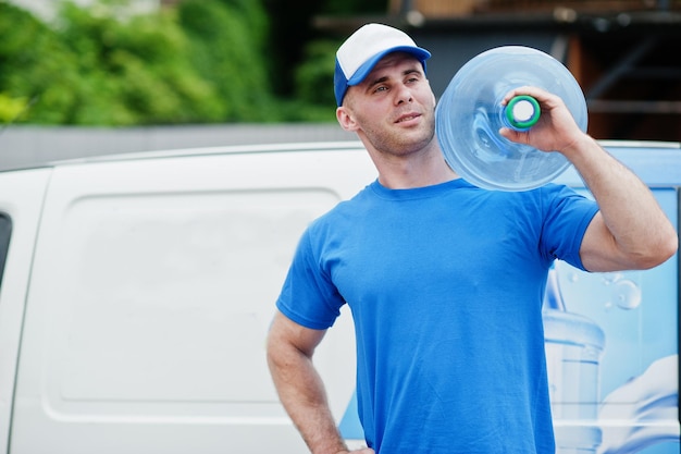 Lieferbote im vorderen Lieferwagen, der Wasserflaschen liefert