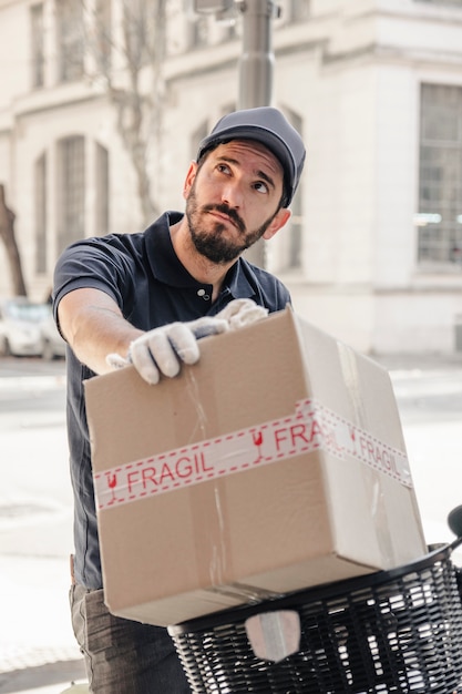 Lieferbote mit dem Paket, das weg schaut