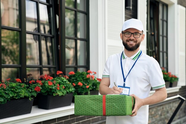 Lieferbote mit Geschenkbox und Ordner