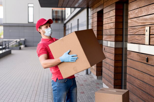 Lieferbote mit Maske und Handschuhen