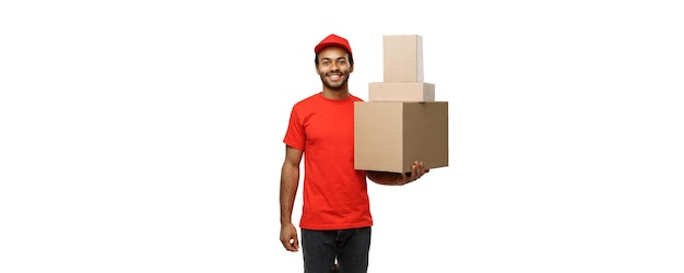 Lieferkonzept Porträt eines glücklichen afroamerikanischen Lieferers in rotem Tuch, der ein Kartonpaket hält, das auf weißem Studio-Hintergrund-Kopienraum isoliert ist