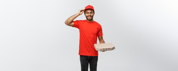 Lieferkonzept Porträt eines gutaussehenden afroamerikanischen Pizzaboten isoliert auf grauem Studio-Hintergrund-Kopienraum