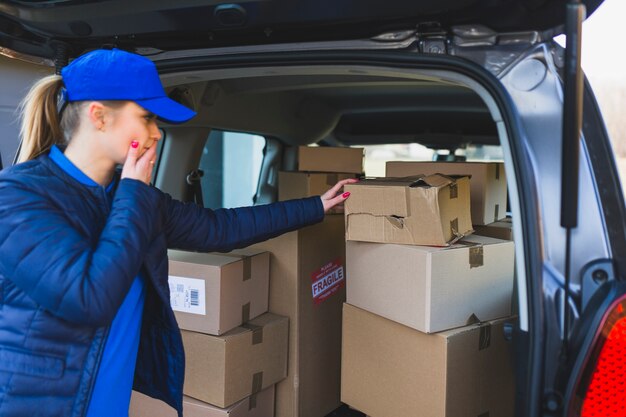 Lieferperson, die Probleme mit dem Transportieren des Pakets hat