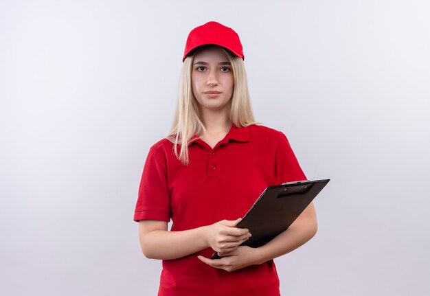 Lieferung junge Frau, die rotes T-Shirt und Kappe hält Zwischenablage auf isolierter weißer Wand hält