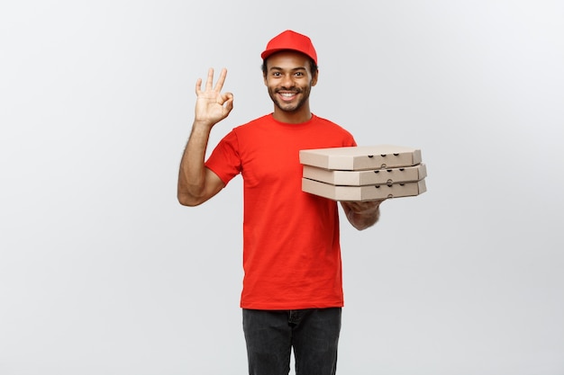 Lieferung Konzept - Porträt von Handsome African American Pizza Lieferung Mann. Isoliert auf grau studio Hintergrund. Text kopieren