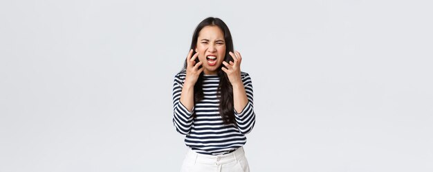 Lifestyle-Menschen Emotionen und lässiges Konzept Verrückte verzweifelte asiatische Frau, die die Beherrschung verliert, kann es nicht mehr ertragen, Ärger loszulassen und sich darüber zu beschweren, dass sie schreit, als hätte sie ein Argument, das aggressiv die Hände schüttelt
