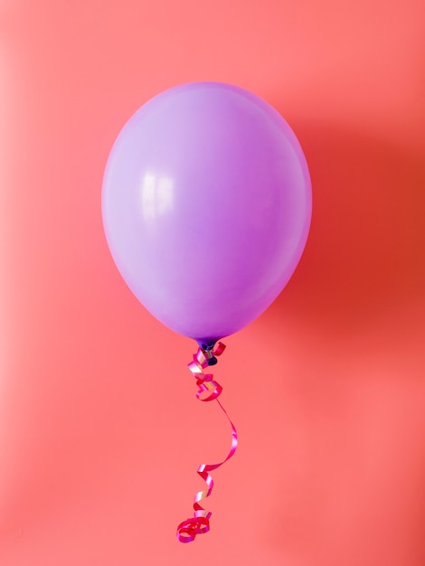 Lila Ballon auf rosa Hintergrund