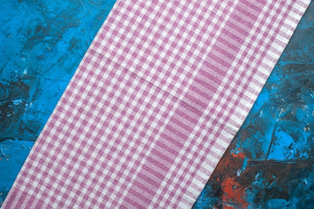 Kostenloses Foto lila handtuch der draufsicht auf blauem hintergrund