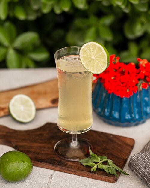 Limonade mit Eiswürfeln und Limettenscheibe.