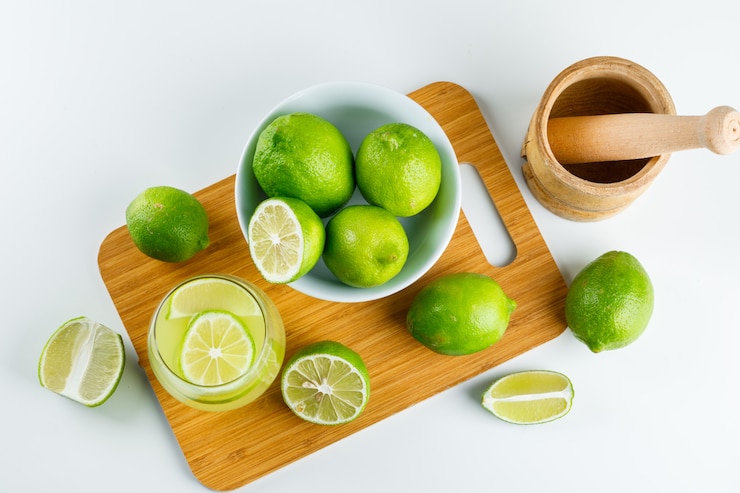 Kostenlose Foto limonade mit zitrone, mörser und pistill in einem glas auf weiß und schneidebrett, flach legen.