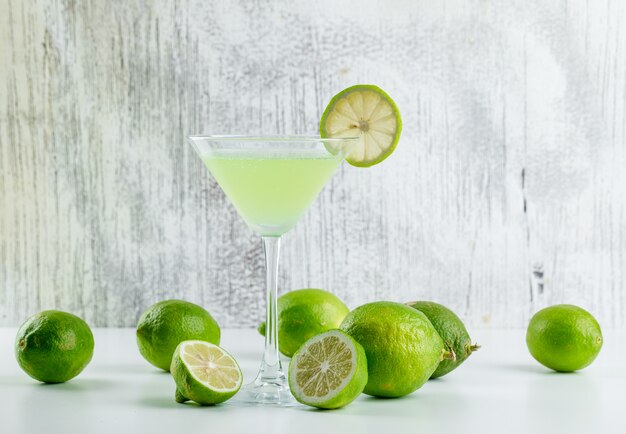 Limonade mit Zitronen in einem Glas auf weiß und grungy,