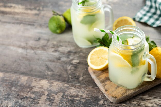 Limonadengetränk in einem Glasglas und Zutaten auf Holztisch