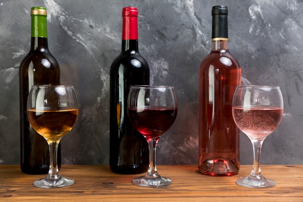 Linie von Weinflaschen und Weingläsern