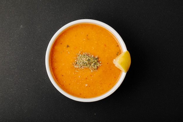 Linsensuppe mit Gewürzen und Zitronenscheibe.