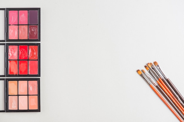 Lippenstiftpalette mit Bürsten auf weißem Hintergrund