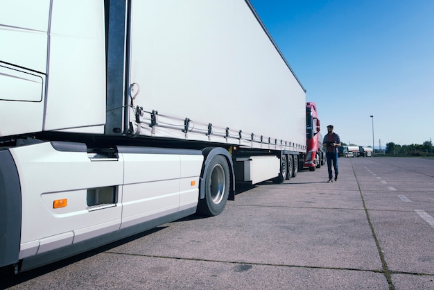 LKW-Fahrer inspiziert das lange Fahrzeug des LKW vor dem Fahren