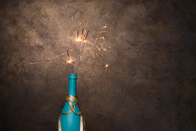 Kostenloses Foto lodernde bengallichter in der flasche des getränks