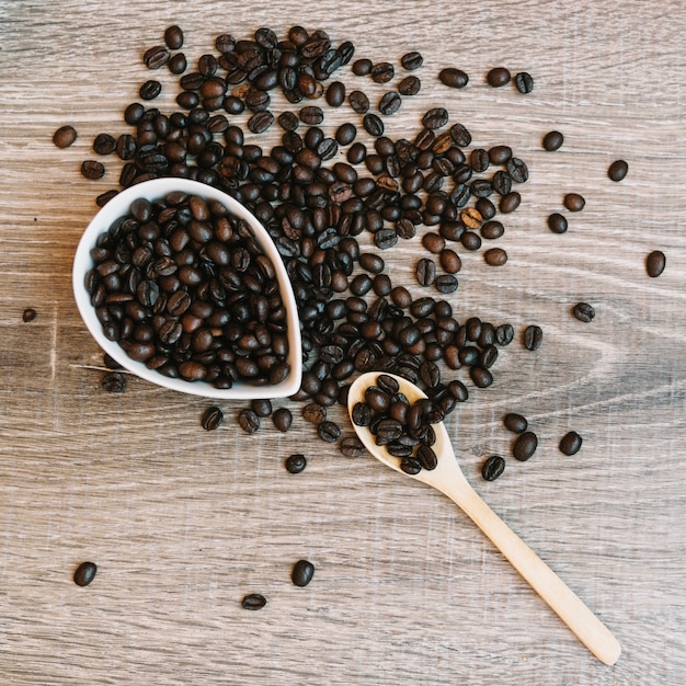 Löffel und keramische Schüssel mit Kaffeebohnen