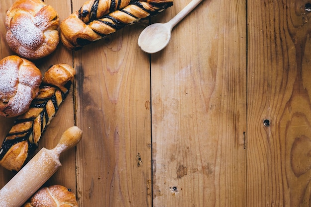 Löffel und Nudelholz in der Nähe von Brötchen