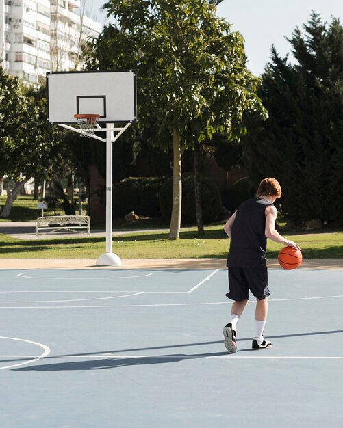 Long Shot des Jungen, der Basketball spielt