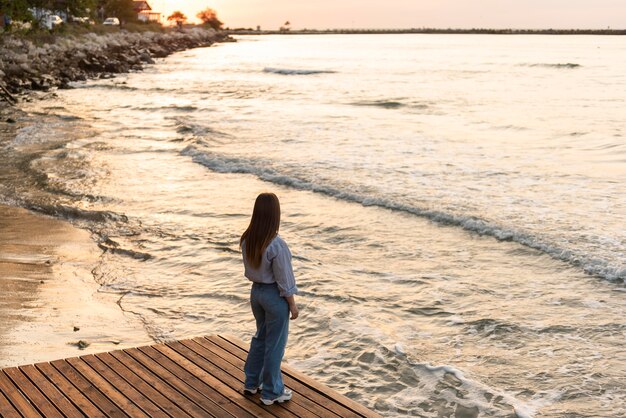 Long Shot Frau, die das Meer betrachtet