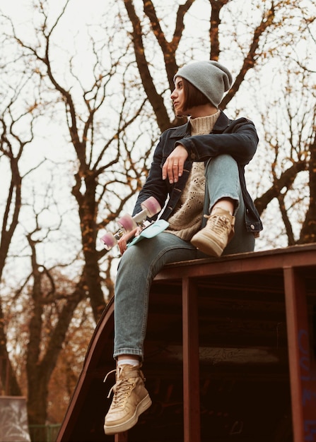 Kostenloses Foto long shot frau hält ein skateboard