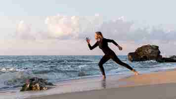 Kostenloses Foto long shot frau läuft am strand