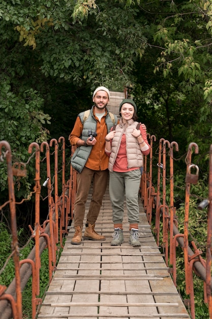 Long Shot junges Paar, das auf Holzbrücke geht