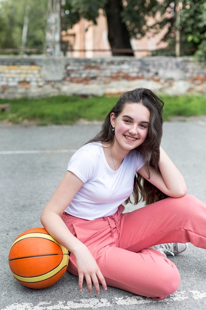 Long Shot Mädchen hält einen Basketball