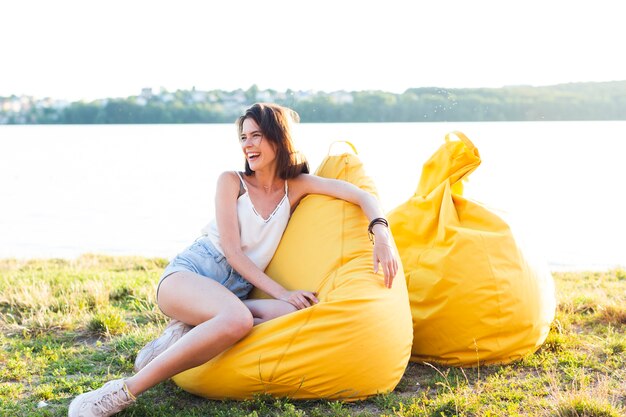 Long Shot schöne Frau posiert auf gelben Sitzsack