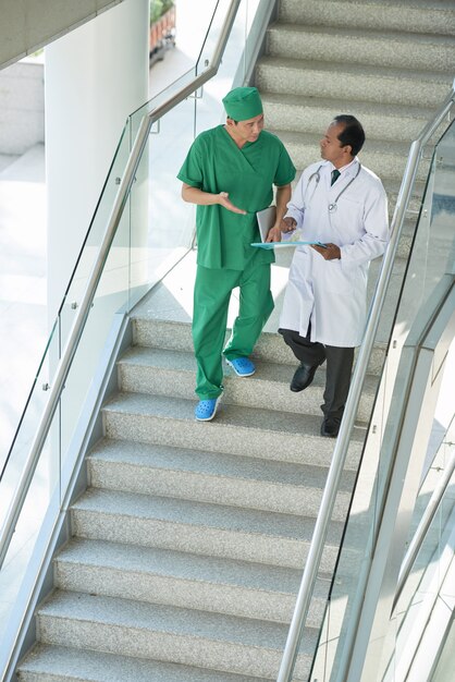 Long Shot von zwei Ärzten, die die Krankenhaustreppe hinuntergehen
