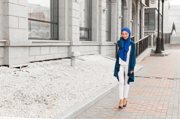 Long Shot wunderschönes Mädchen mit Hijab lächelnd