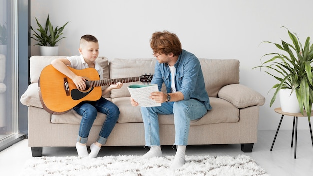 Long View Schüler und Lehrer spielen Gitarre