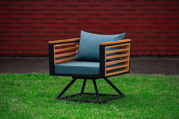 Loungesessel im Loft-Stil mit blauen Kissen und Möbeln auf dem Rasen