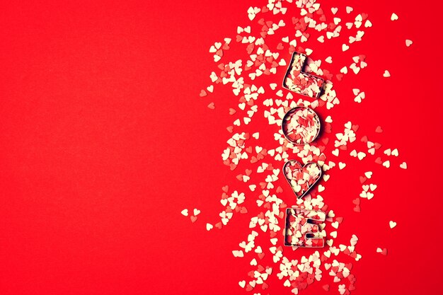 Love-Konzept mit Buchstaben LIEBE und die Schatze auf einem roten backgrou