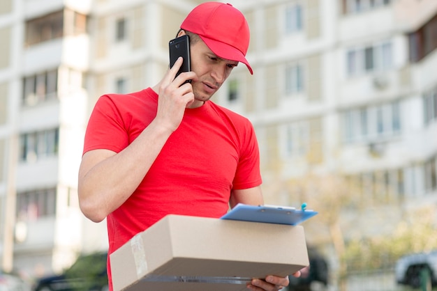 Kostenloses Foto low angle delivery guy mit telefon