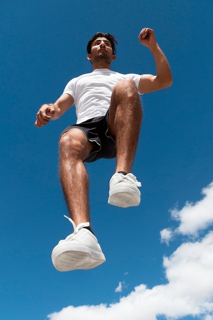 Low Angle Fit Mann springt im Freien