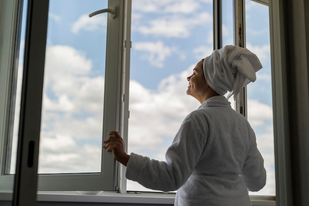 Low Angle Frau schaut aus dem Fenster