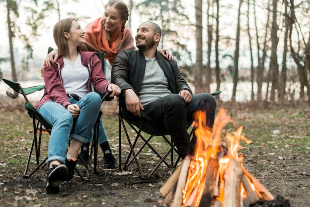 Low Angle Freunde sitzen am Lagerfeuer