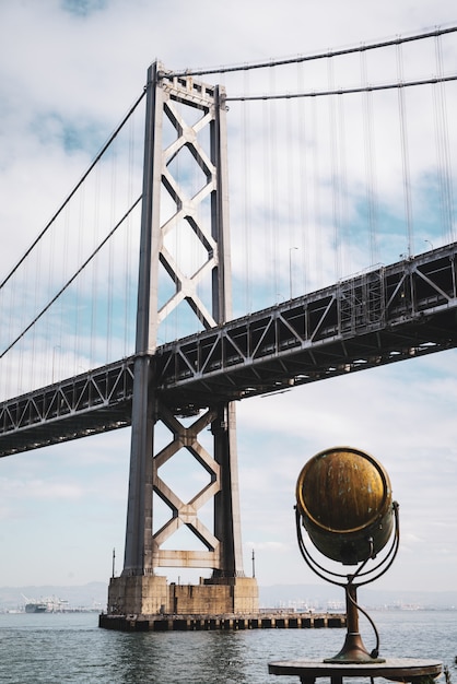 Kostenloses Foto low angle shot der san francisco oakland bay bridge unter dem bewölkten himmel