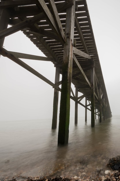 Low angle shot des holzstegs unter einem malerischen bewölkten himmel