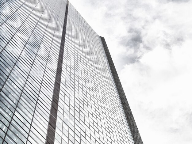 Low Angle Shot eines modernen Glas-Wolkenkratzers an einem bewölkten Himmel