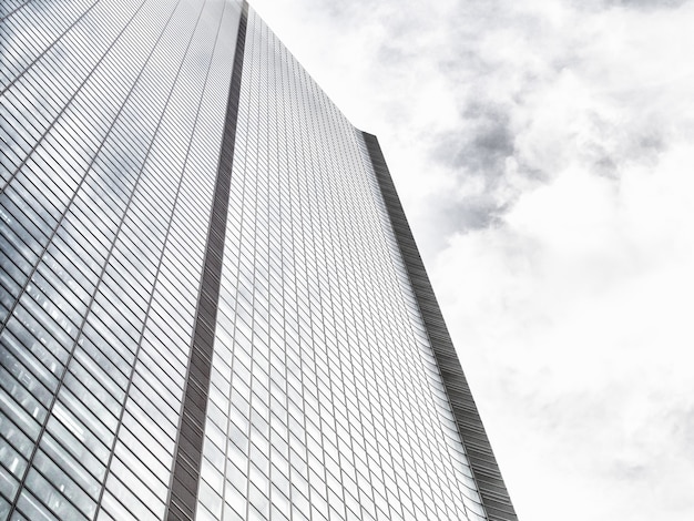 Low Angle Shot eines modernen Glas-Wolkenkratzers an einem bewölkten Himmel