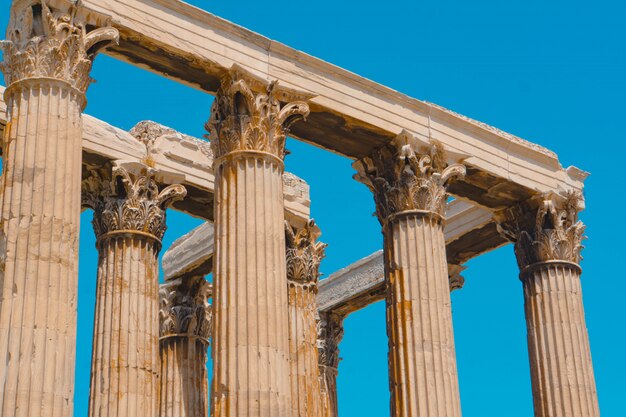 Low Angle Shot von alten griechischen Steinsäulen mit einem klaren blauen Himmel