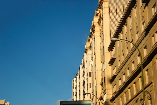 Low Angle Shot von Straßenlaternen und Wohngebäuden unter blauem Himmel