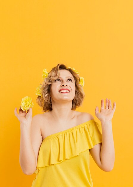 Low Angle Smiley Frau mit gelben Blumen