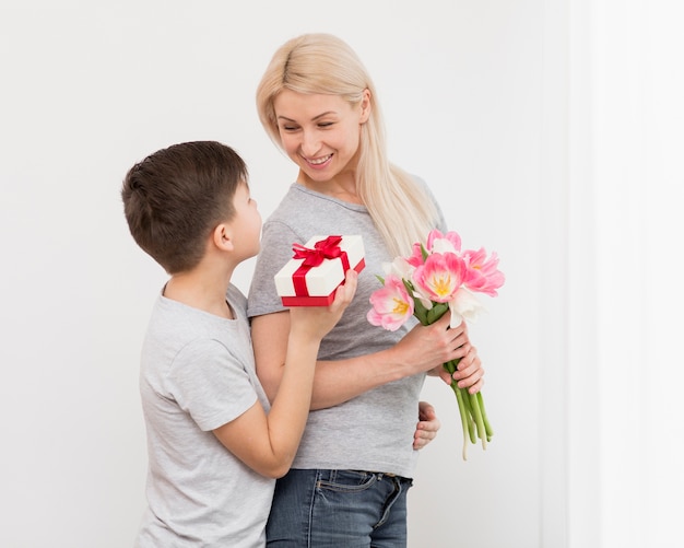 Low Angle Sohn bietet Mutter ein Geschenk an