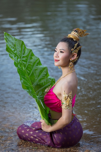 Kostenloses Foto loy krathong festival. frau im thailändischen traditionellen outfit, das bananenblatt hält